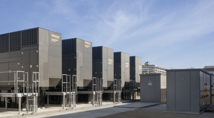 a row of Generac diesel generators lined up under a blue sky