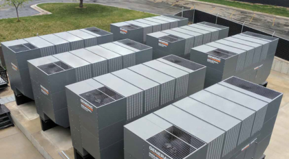 angled overhead view of 7 large Generac diesel generators in an outdoor setting showing their paralleling power