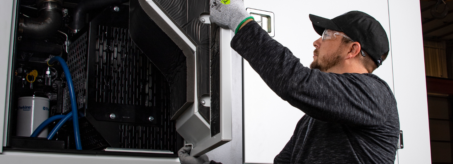 close in photo of a service technician removing the side door from a Generac mobile generator aligning to the mobile generator owners manual